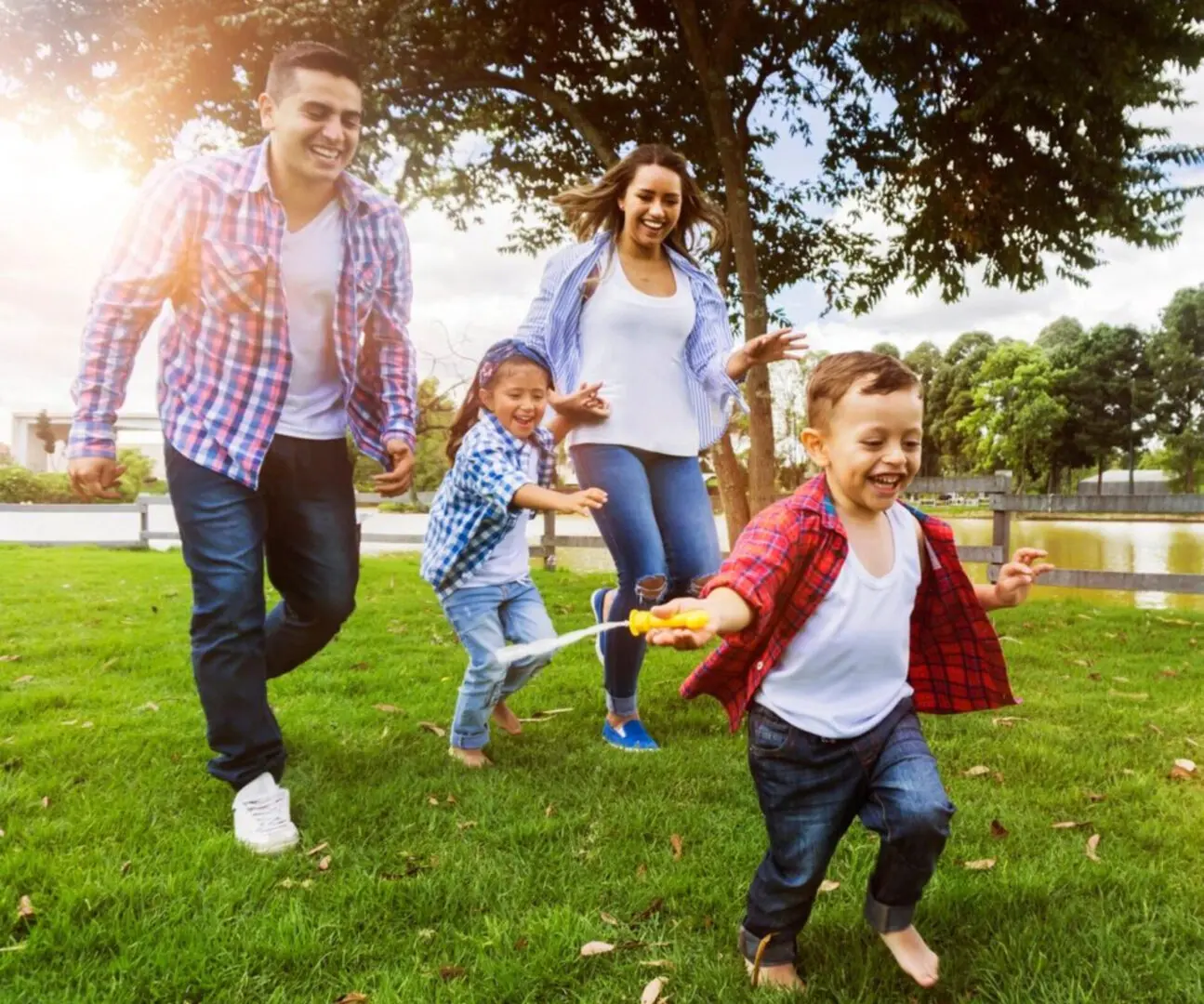 A family is smiling and running in the park