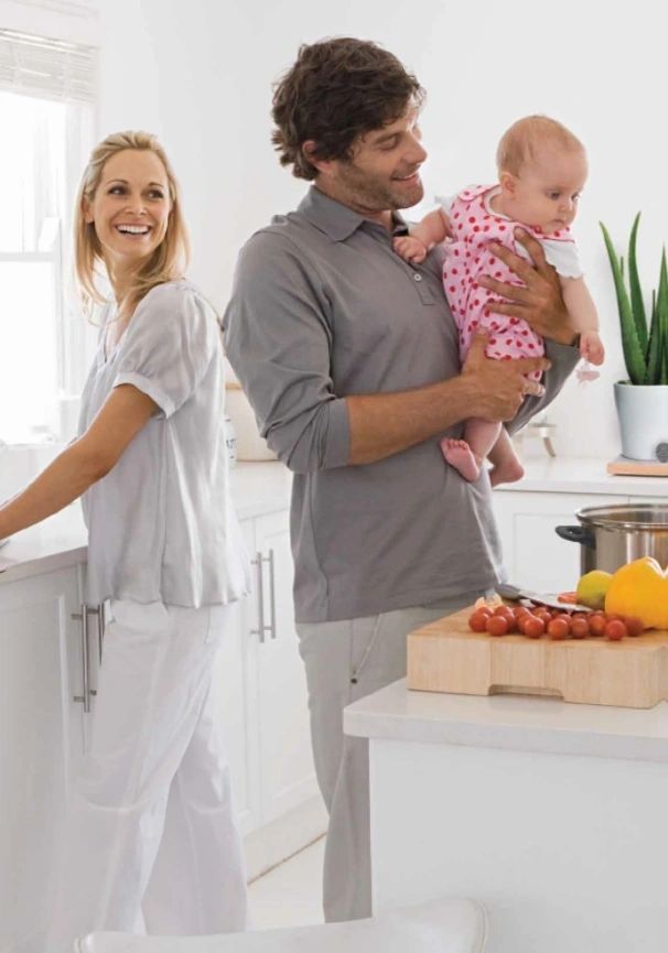 Happy family cooking together in a bright kitchen.